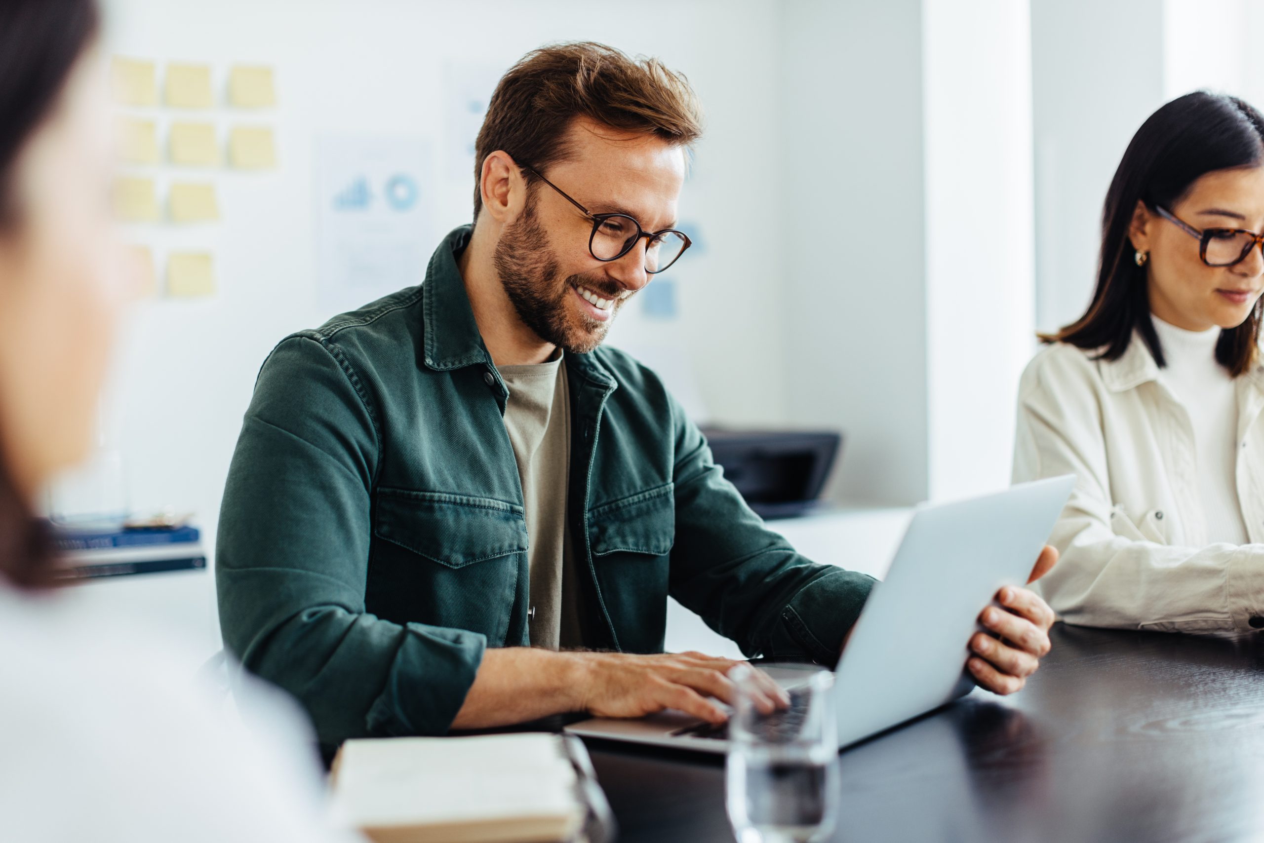Designer using a laptop while sitting in a meeting Designer using a laptop while sitting in a meeting